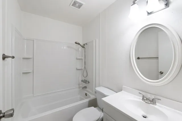 a bathroom with a sink a mirror a toilet and a bathtub