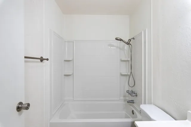 a bathroom with a shower and a bath tub