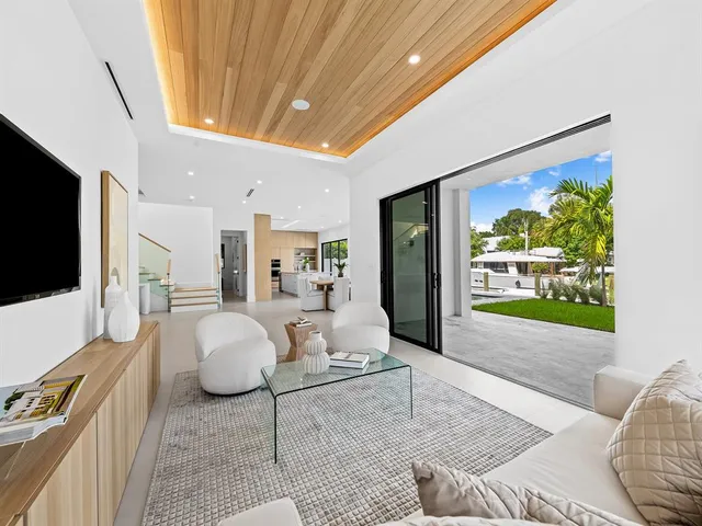 a living room with couches and kitchen view with wooden floor