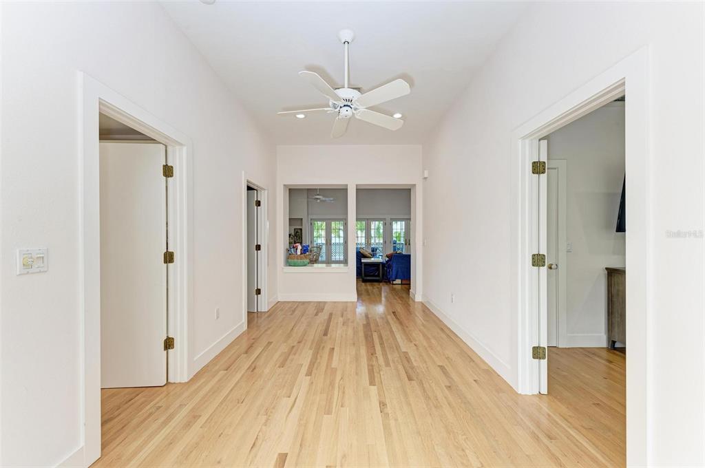 7520 Manasota Key Road Englewood, FL 34223 - Photo 32 of 96 a view of a hallway with wooden floor and a chandelier