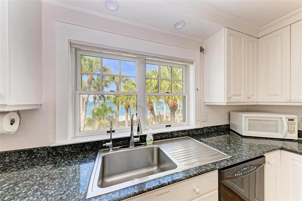 7520 Manasota Key Road Englewood, FL 34223 - Photo 44 of 96 a kitchen with granite countertop a sink window and cabinets