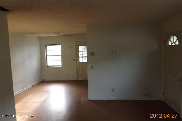 7503 Strato Road Jacksonville, FL 32210 - Photo 3 of 8 an empty room with wooden floor and windows