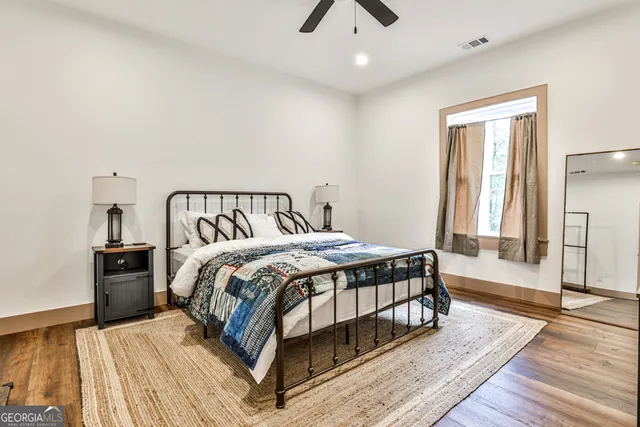a bedroom with a bed and wooden floor