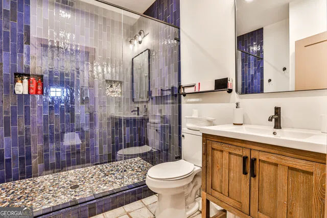 a bathroom with a sink a toilet and shower