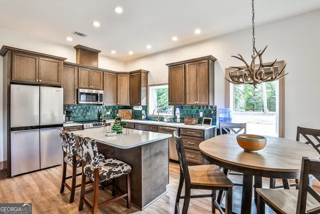 a kitchen with a table chairs and refrigerator