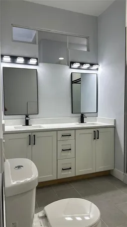 a bathroom with a sink a toilet and mirror