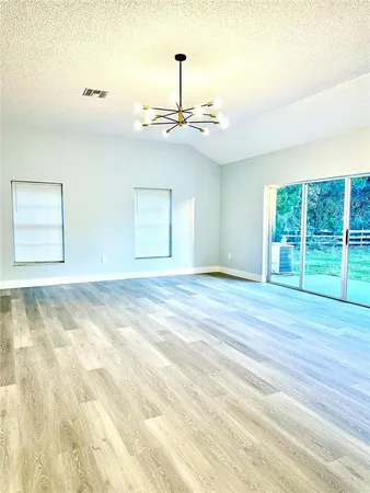 a view of a room with wooden floor fan and window