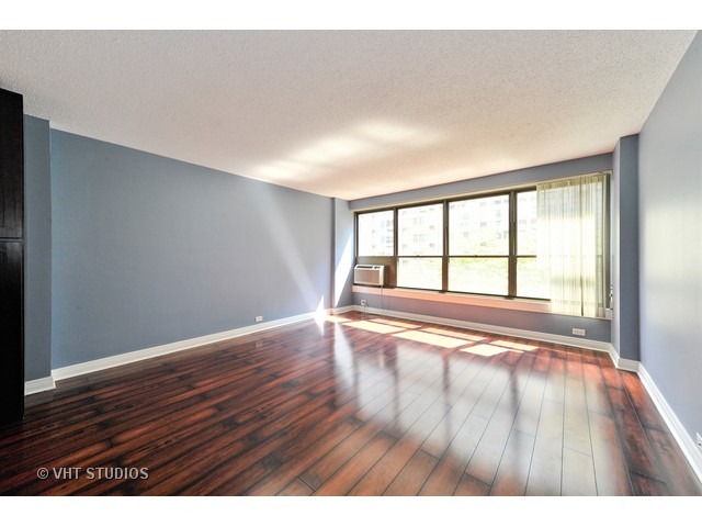2930 North Sheridan Road, Unit 511 Chicago, IL 60657 - Photo 2 of 10 a view of an empty room with wooden floor and a window