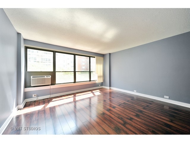 2930 North Sheridan Road, Unit 511 Chicago, IL 60657 - Photo 4 of 10 wooden floor in an empty room with a window