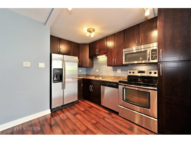 2930 North Sheridan Road, Unit 511 Chicago, IL 60657 - Photo 5 of 10 a kitchen with stainless steel appliances granite countertop a refrigerator a sink and a stove