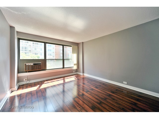 2930 North Sheridan Road, Unit 511 Chicago, IL 60657 - Photo 9 of 10 wooden floor in an empty room with a window