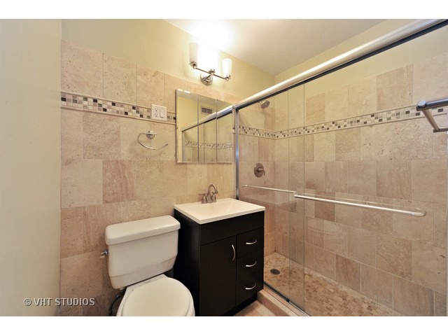 2930 North Sheridan Road, Unit 511 Chicago, IL 60657 - Photo 10 of 10 a bathroom with a sink mirror vanity and toilet