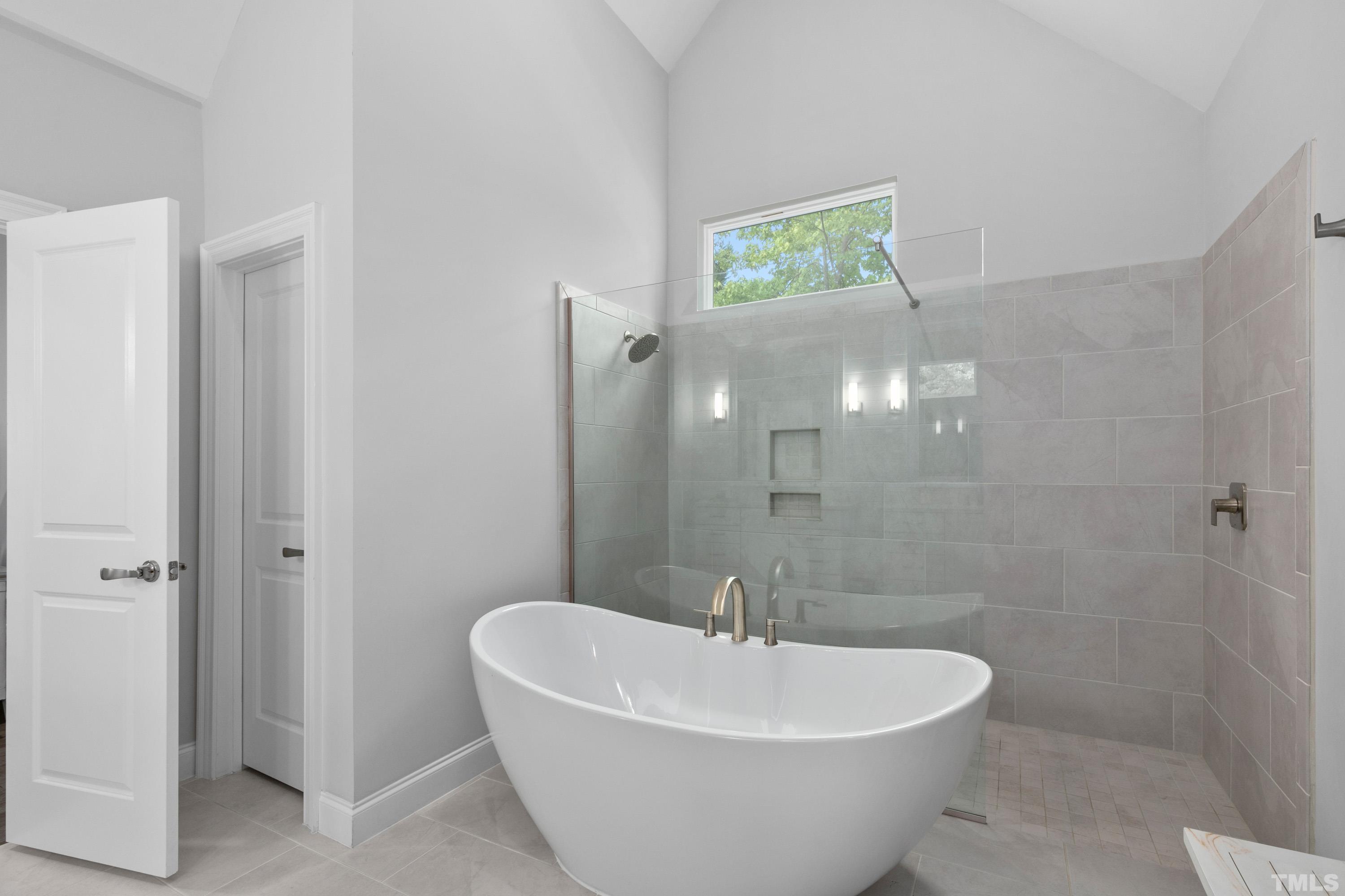 8017 Shree Court Raleigh, NC 27613 - Photo 13 of 30 a bath room with a white tub shower and a sink