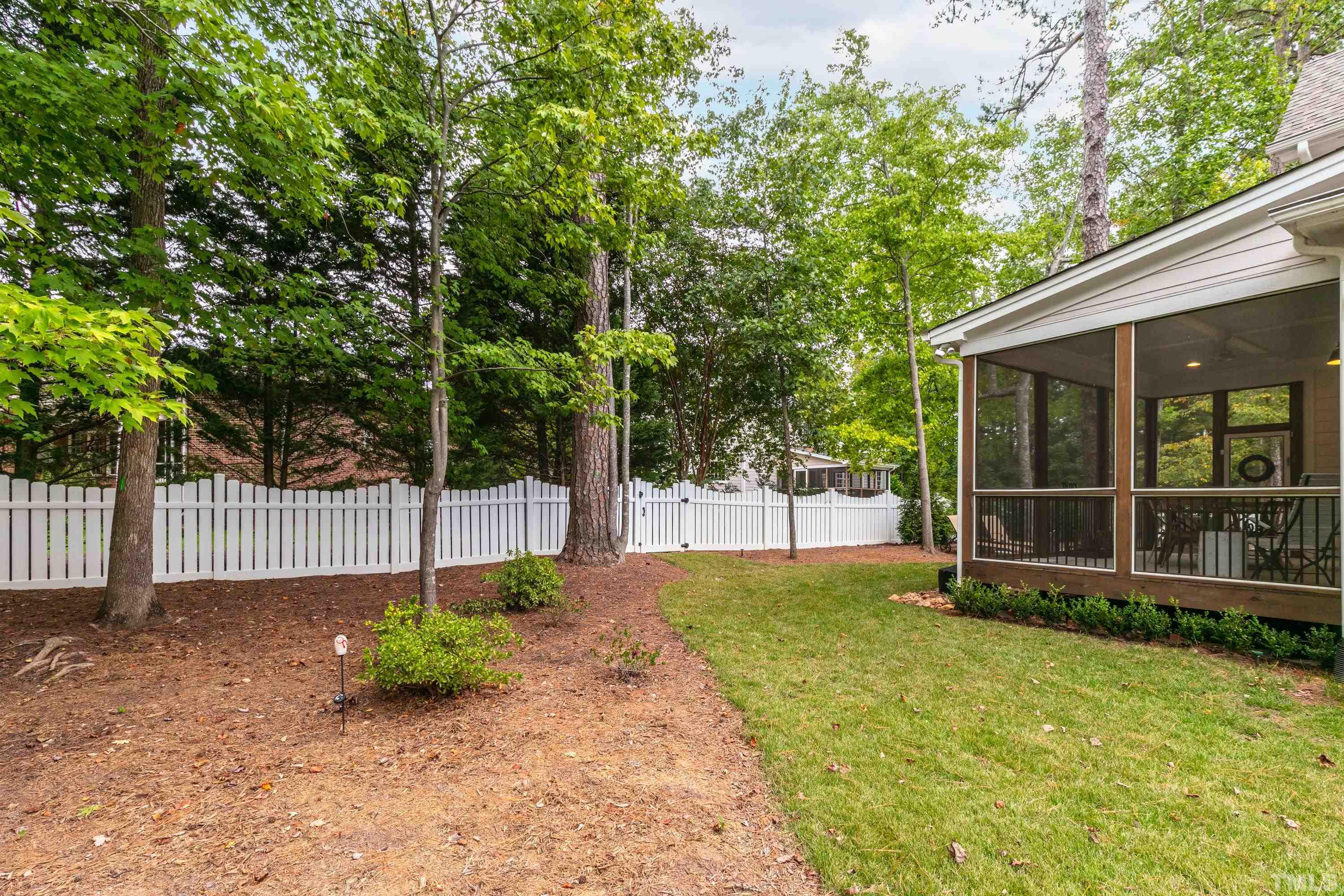 8017 Shree Court Raleigh, NC 27613 - Photo 28 of 30 a view of a backyard with large trees and wooden fence