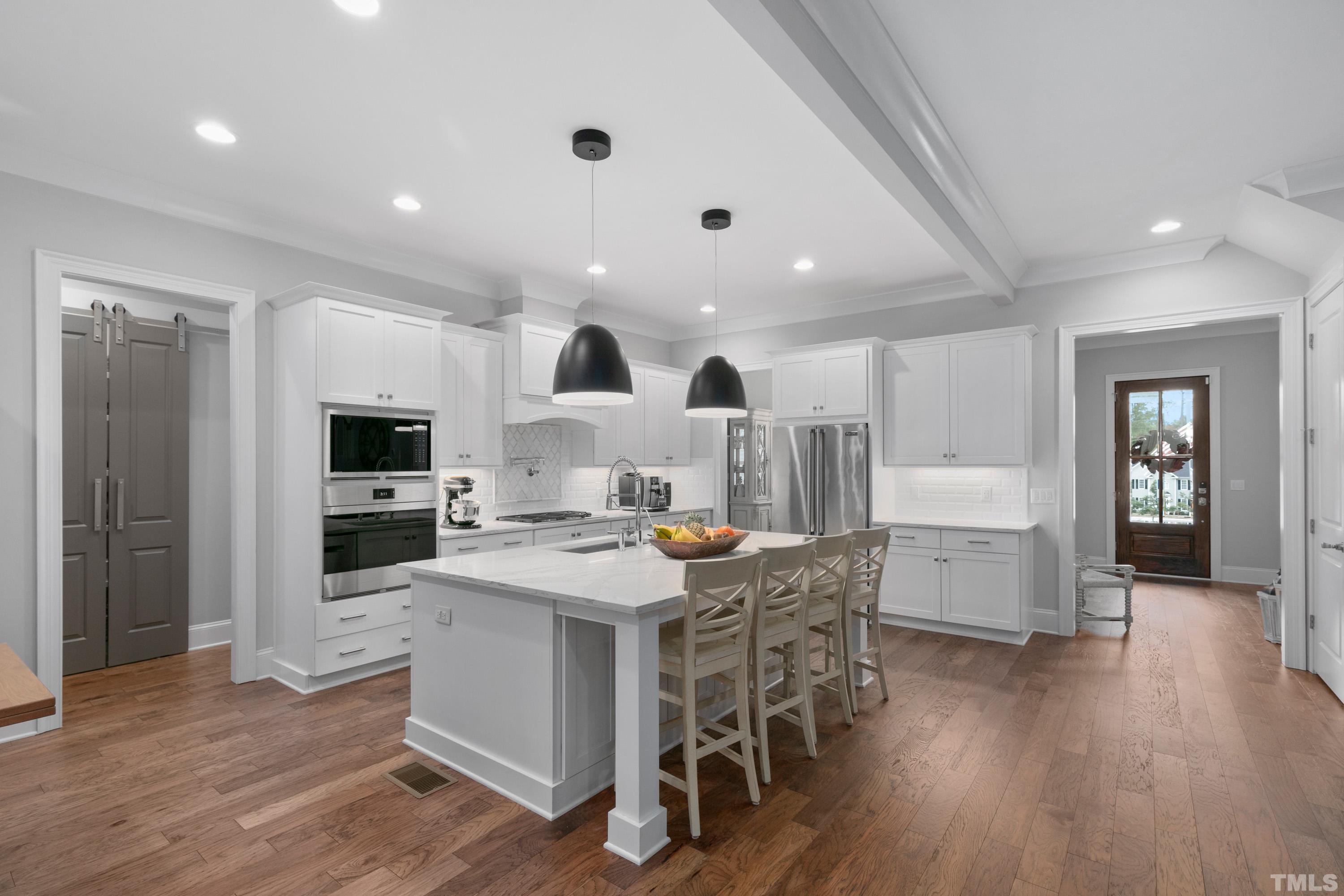 8017 Shree Court Raleigh, NC 27613 - Photo 8 of 30 a large white kitchen with a table and chairs