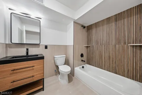 a bathroom with a toilet a sink a mirror and bathtub