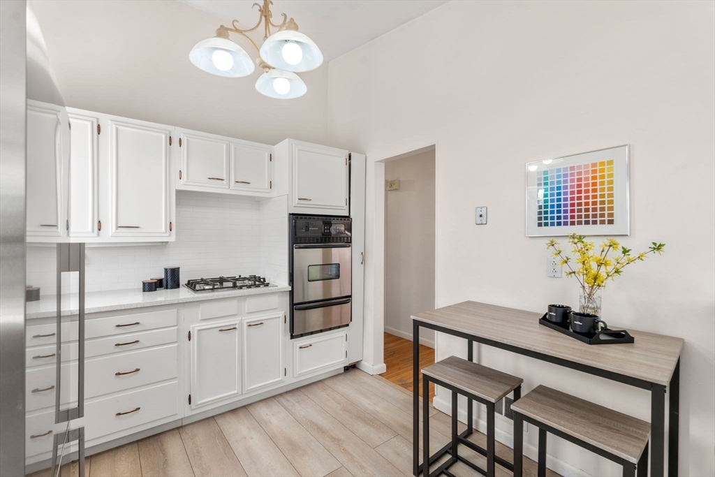 14 Fuller Avenue Newton, MA 02465 - Photo 8 of 27 a kitchen with stainless steel appliances a stove a sink cabinets and wooden floor