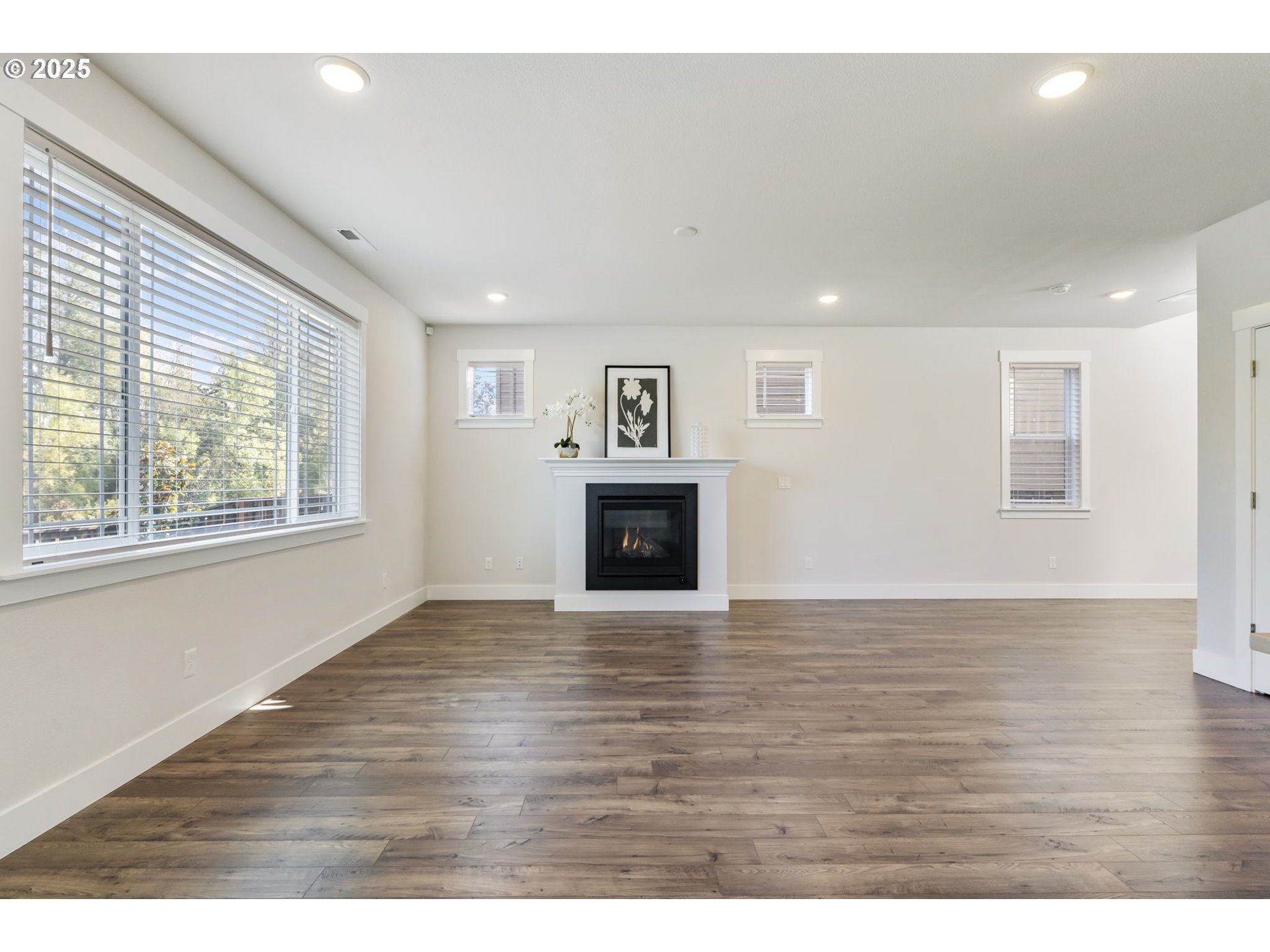 18246 Southwest Silvertip Street Beaverton, OR 97007 - Photo 13 of 46 a view of empty room with wooden floor and fireplace