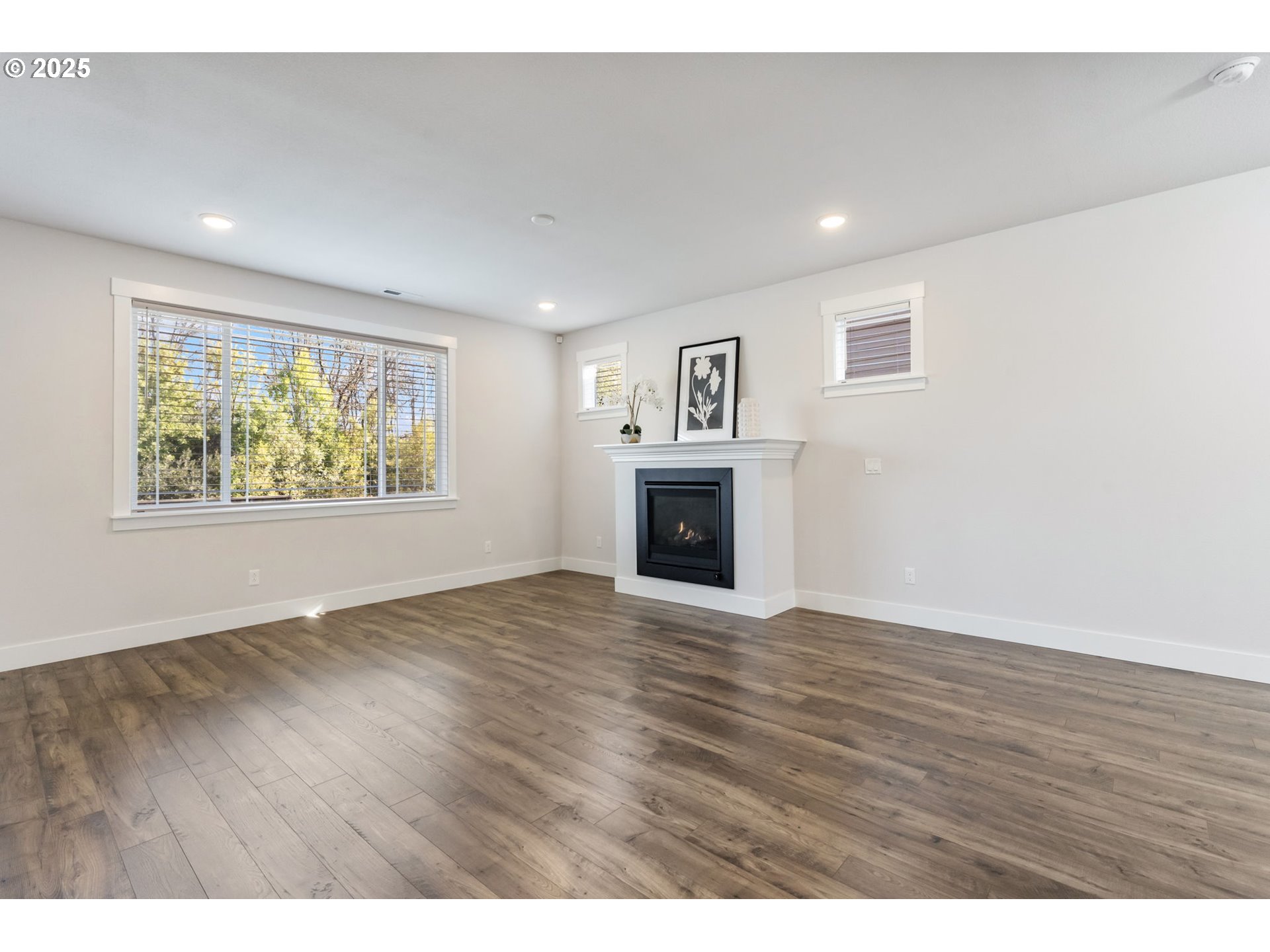 18246 Southwest Silvertip Street Beaverton, OR 97007 - Photo 8 of 46 a view of empty room with wooden floor and fireplace