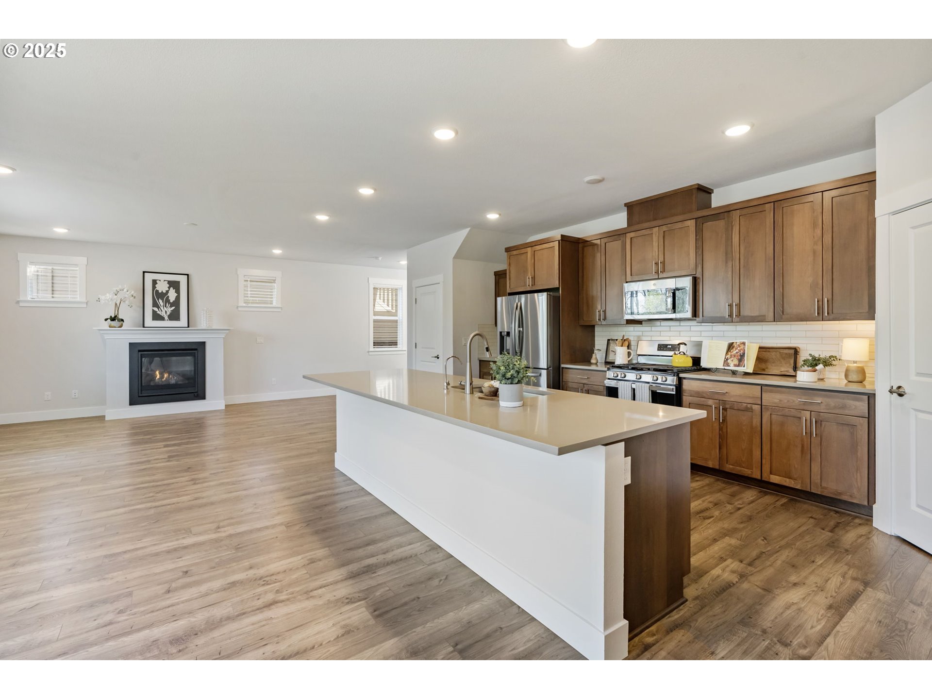 18246 Southwest Silvertip Street Beaverton, OR 97007 - Photo 10 of 46 a open kitchen with kitchen island a sink a stove and a refrigerator
