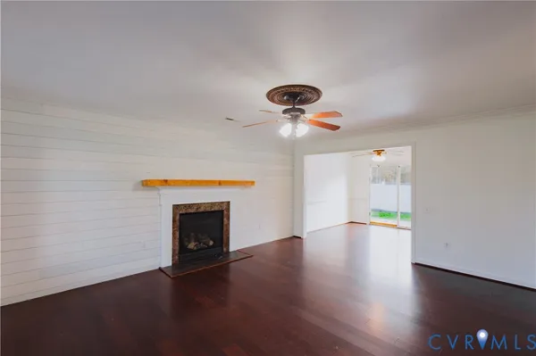 an empty room with a chandelier fan and windows