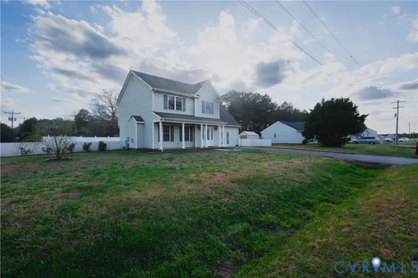 a front view of a house with a yard and wooden fence