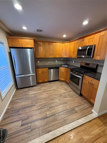 a kitchen with stainless steel appliances granite countertop a stove a sink and a refrigerator