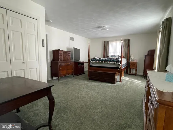 a bathroom with a granite countertop sink a toilet and a mirror