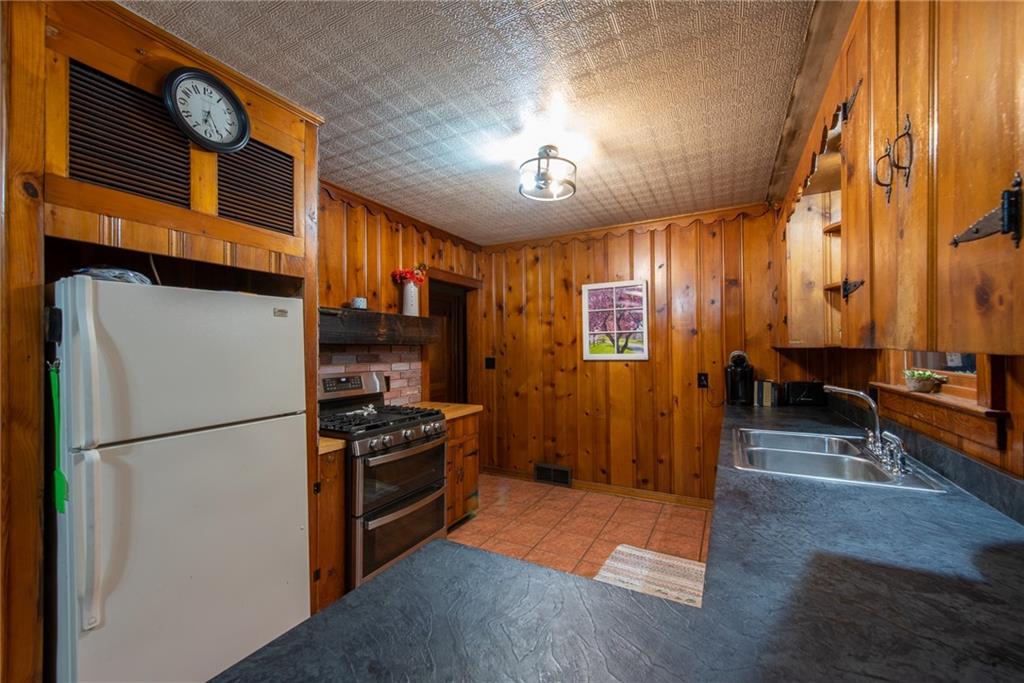 250 Rhoda Avenue Leechburg, PA 15656 - Photo 9 of 38 a kitchen with stainless steel appliances granite countertop a refrigerator a stove and a sink with wooden floor