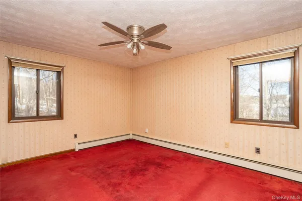 an empty room with a window and a fan