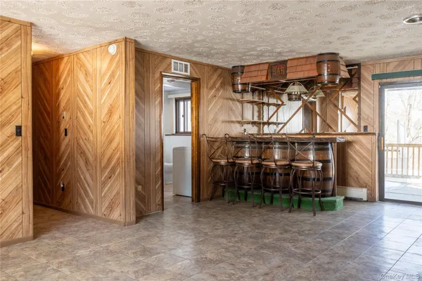 a view of a house with a wooden bench and furniture