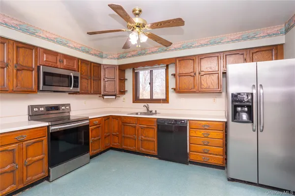 a kitchen with stainless steel appliances granite countertop a stove sink microwave and refrigerator
