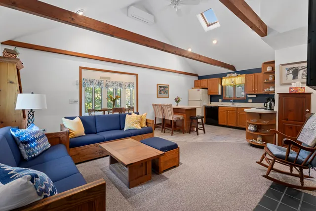 a living room with furniture kitchen view and a large window