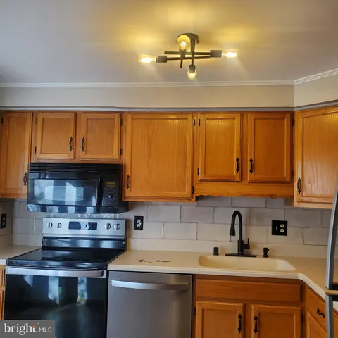 a kitchen with a sink stove top oven and cabinets