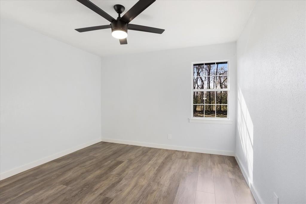 110 East Cunningham Street Bonham, TX 75418 - Photo 14 of 26 an empty room with wooden floor and windows