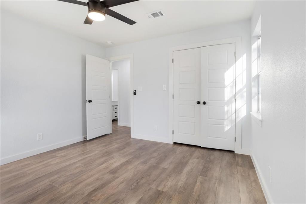 110 East Cunningham Street Bonham, TX 75418 - Photo 15 of 26 an empty room with wooden floor and windows