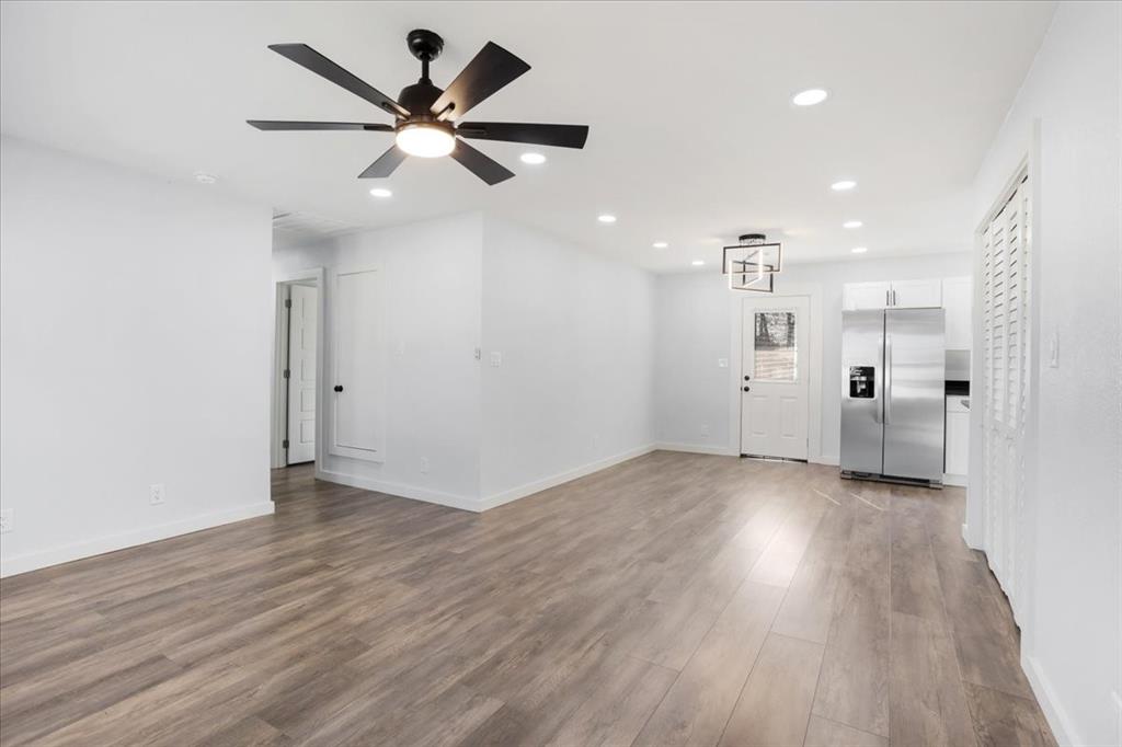 110 East Cunningham Street Bonham, TX 75418 - Photo 3 of 26 wooden floor in an empty room with a ceiling fan