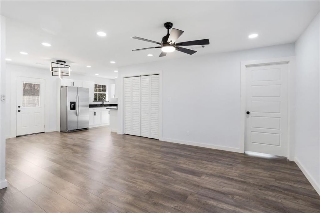 110 East Cunningham Street Bonham, TX 75418 - Photo 4 of 26 a view of a big room with wooden floor a ceiling fan and windows