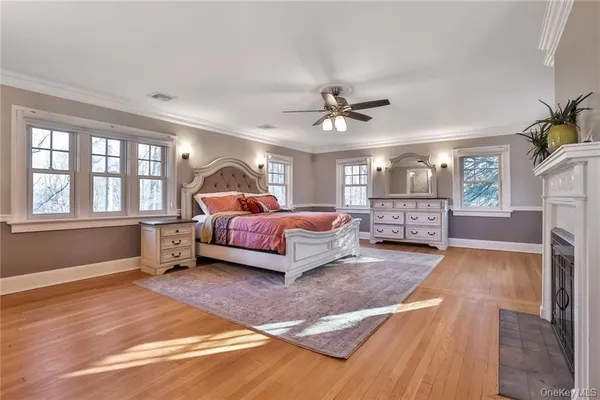 a spacious bedroom with a large bed a chandelier and windows