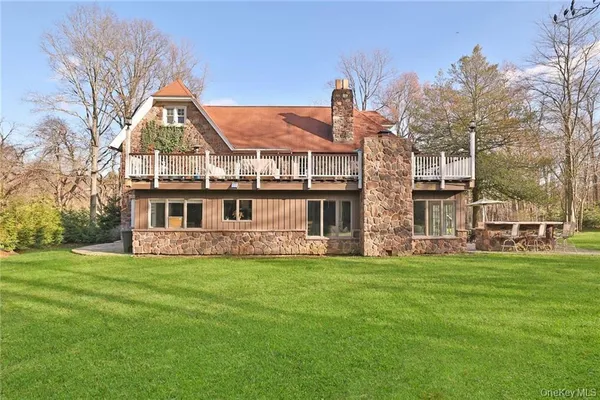 a view of a house with a big yard and large trees