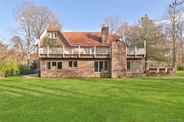 a view of a house with a big yard and large trees