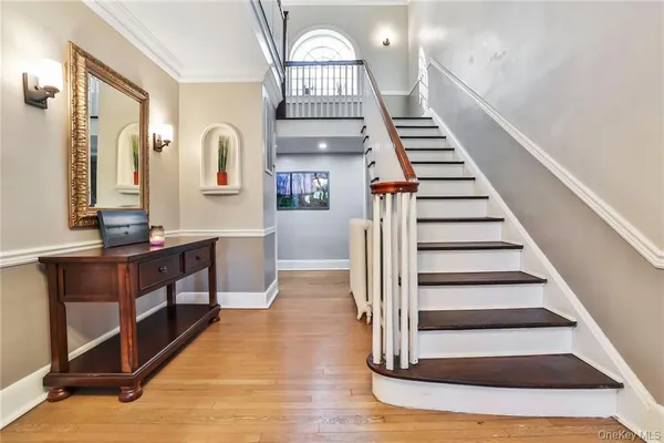 a view of entryway and hall with wooden floor