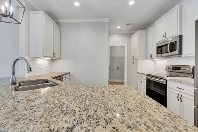 a kitchen with stainless steel appliances granite countertop a sink stove and refrigerator