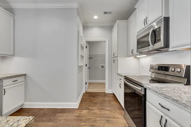 a kitchen with stainless steel appliances granite countertop a stove a microwave and a refrigerator