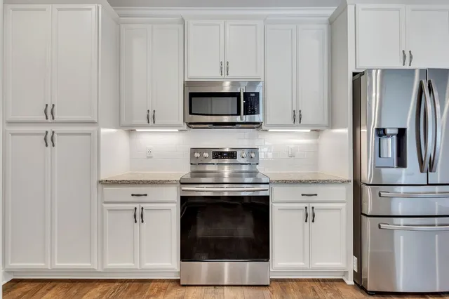 a kitchen with stainless steel appliances granite countertop a stove a refrigerator and a microwave