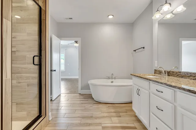 a spacious bathroom with a bathtub sink and mirror