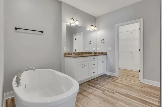 a spacious bathroom with a granite countertop sink a mirror and shower