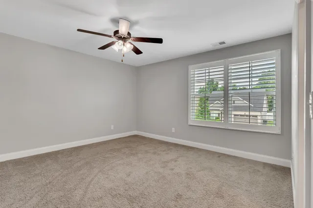 an empty room with a window and a fan