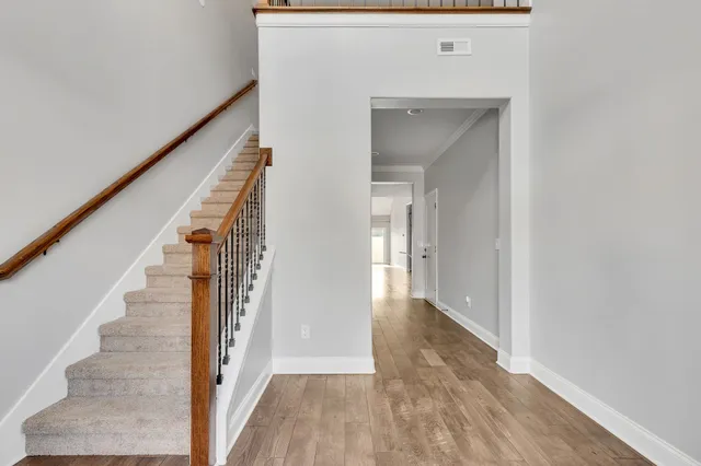 a view of a hallway with wooden floor and staircase