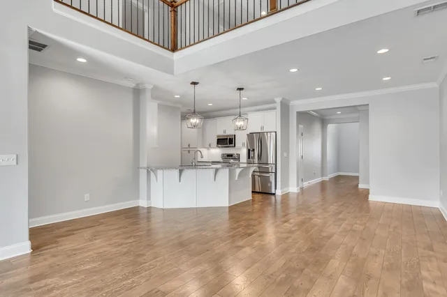 a view of kitchen with stainless steel appliances kitchen island granite countertop a refrigerator a stove and a sink with wooden floor